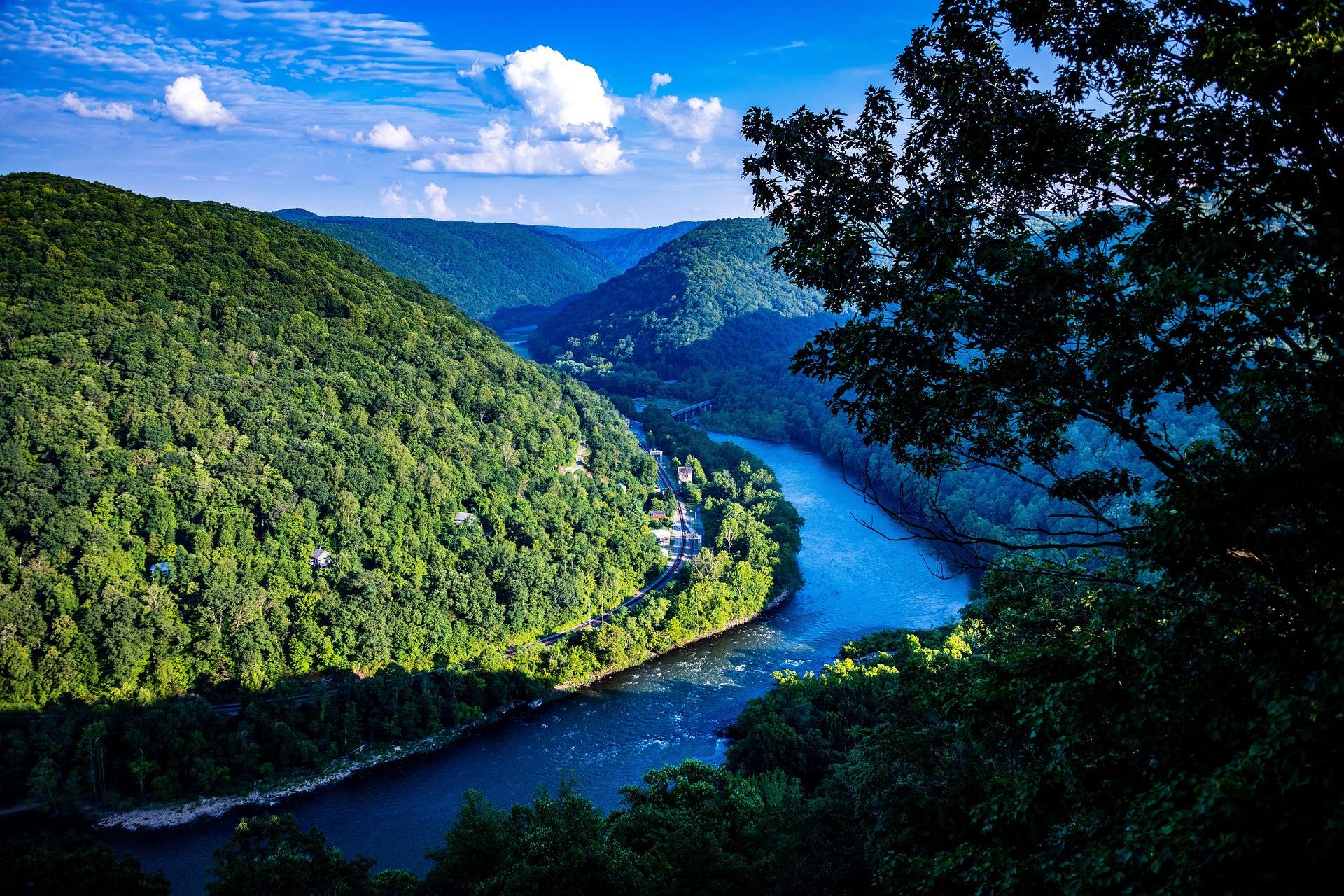 The New River winding far below steep forested canyon walls in West Virginia on a bright summer day